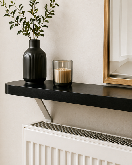 Black Loby radiator shelf mounted above a radiator, with the support bracket running down behind it