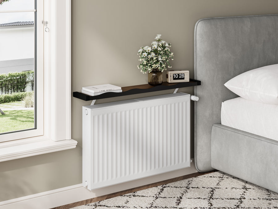 Black & Walnut — Loby Wavy radiator shelf fitted in a bedroom, styled with flowers and a clock