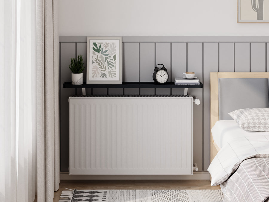 Black — Loby Curve radiator shelf in black, fitted above a radiator in a home interior