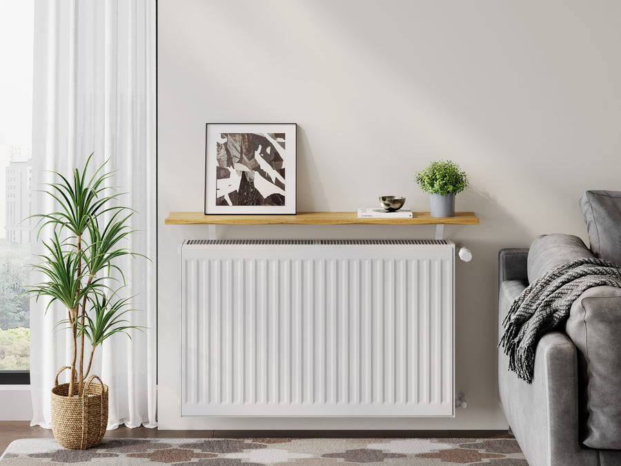 Ash — Pine radiator shelf in the ash finish, fitted above a radiator in a living room with a framed print